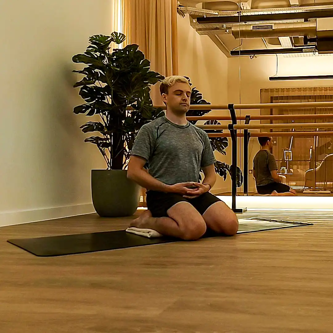 Man meditating on white blanket